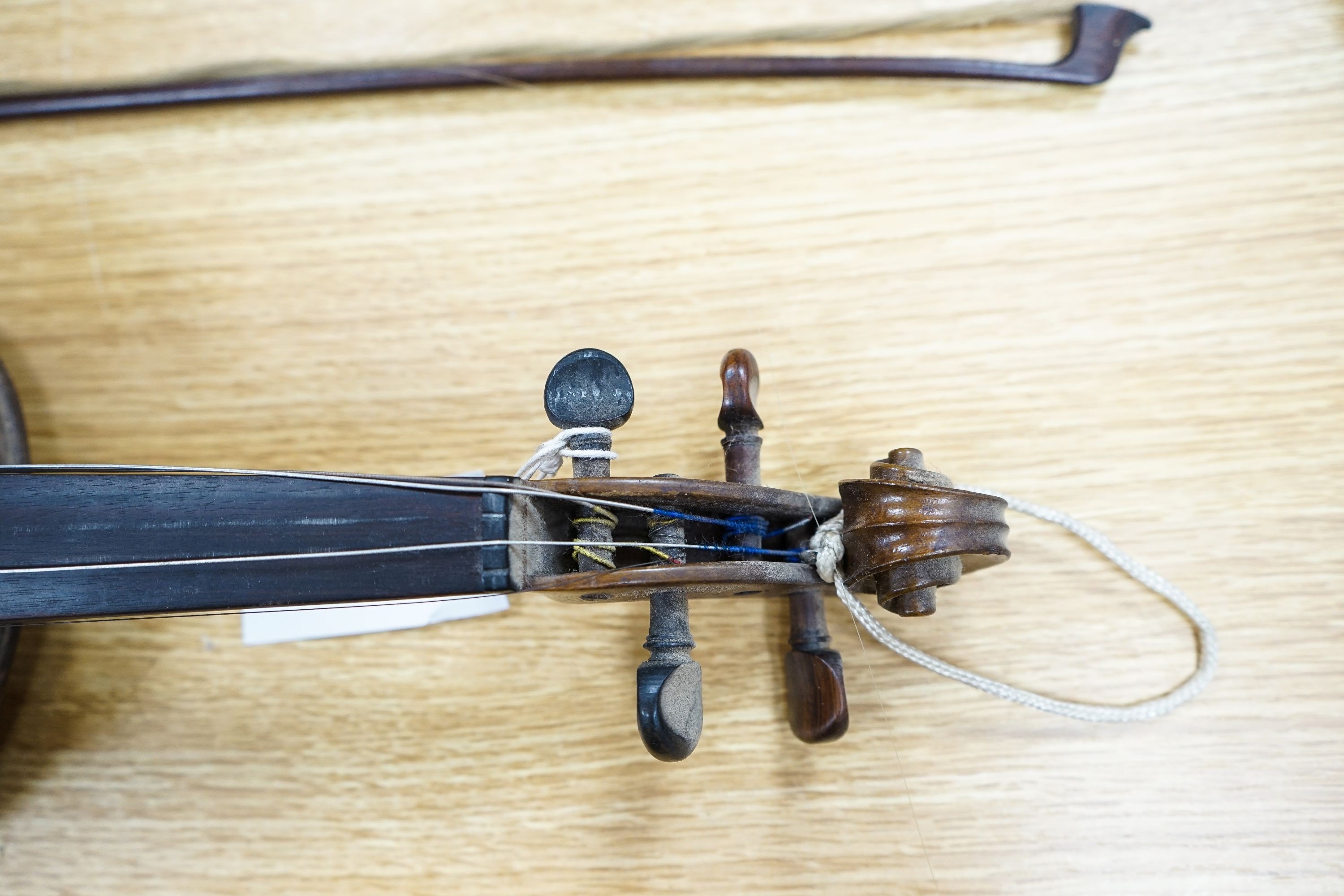 A violin labelled Francesco Ruggeri and a bow. Back of violin excluding button - 36cm